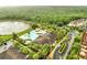An aerial view of the community featuring a pool, tennis court, pond, and tree coverage at 2820 Oakwater Dr # 2820, Kissimmee, FL 34747