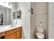 Bathroom with a wooden vanity with a sink and toilet with assistive handrails at 2820 Oakwater Dr # 2820, Kissimmee, FL 34747