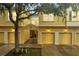 Inviting yellow townhome with individual garages, a walkway to front door and mature landscaping at 2820 Oakwater Dr # 2820, Kissimmee, FL 34747