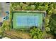 Aerial view of the tennis court surrounded by lush landscaping and parking at 2820 Oakwater Dr # 2820, Kissimmee, FL 34747