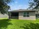 Spacious backyard featuring lush green grass and a screened-in patio, perfect for outdoor enjoyment at 326 Charles Dr, Deland, FL 32724