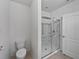 Bright bathroom featuring a glass-enclosed shower with grab bars and a white toilet at 326 Charles Dr, Deland, FL 32724