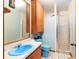 Full bathroom with light blue walls, white tiled shower, and blue fixtures at 3580 Ne 160Th Ln, Citra, FL 32113