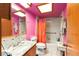 Full bathroom with wood cabinets, granite countertop, and bright pink walls at 3580 Ne 160Th Ln, Citra, FL 32113