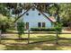 Charming light blue two-story home featuring a unique circular window design and a quaint fenced yard at 3580 Ne 160Th Ln, Citra, FL 32113