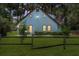 Lovely light blue home with unique round windows, a fenced yard, and ample outdoor lighting for charm and appeal at 3580 Ne 160Th Ln, Citra, FL 32113