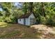 Light blue shed with a roll up garage door surrounded by trees and foliage at 3580 Ne 160Th Ln, Citra, FL 32113