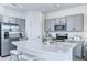 Bright, modern kitchen with stainless steel appliances, gray cabinets, and a large quartz island at 3603 Davenport Creek Ct, Kissimmee, FL 34746