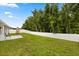 Wide backyard features a playset and a white vinyl fence providing privacy at 3610 Doe Run Dr, St Cloud, FL 34772