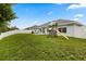 Backyard with a grassy lawn, a wooden playset, and a white fence at 3610 Doe Run Dr, St Cloud, FL 34772