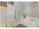 Bathroom featuring a soaking tub and shower with tile walls and pineapple curtain at 3610 Doe Run Dr, St Cloud, FL 34772