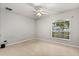 Unfurnished bedroom with a ceiling fan, neutral carpet and walls, and a bright window at 3610 Doe Run Dr, St Cloud, FL 34772
