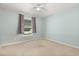 Simple bedroom featuring a ceiling fan, a window and neutral carpeted floors at 3610 Doe Run Dr, St Cloud, FL 34772
