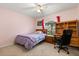 Bedroom with purple accents featuring a window with view, a desk, and a chair at 3610 Doe Run Dr, St Cloud, FL 34772
