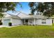 Charming single-story home with a well-manicured lawn, light blue garage door, and cozy front porch at 3610 Doe Run Dr, St Cloud, FL 34772