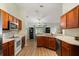 Well-maintained kitchen with wood cabinetry, stainless steel appliances, and wood-look floors at 3610 Doe Run Dr, St Cloud, FL 34772