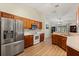 Efficient kitchen featuring wood cabinets, stainless steel appliances, and wood-look flooring at 3610 Doe Run Dr, St Cloud, FL 34772