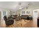 Bright living room boasts vaulted ceilings, wood-look flooring, and comfortable leather seating arrangement at 3610 Doe Run Dr, St Cloud, FL 34772