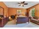 Cozy bedroom boasts a large bed, ceiling fan, colorful artwork and curtains, creating a peaceful retreat at 3798 Lower Union Rd, Orlando, FL 32814