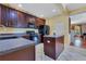 Well-lit kitchen with dark wood cabinetry, black appliances, white tile flooring, and a functional center island at 3798 Lower Union Rd, Orlando, FL 32814