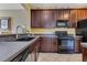 Functional kitchen with stainless steel appliances, dark wood cabinets, and tiled floor at 3798 Lower Union Rd, Orlando, FL 32814