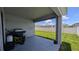 Cozy back porch offers a relaxing space overlooking the lush, green backyard and sunny skies at 394 Pentas Ln, Haines City, FL 33844