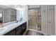 Well-lit bathroom featuring a double vanity, tiled shower with glass door, and modern fixtures for a spa-like experience at 394 Pentas Ln, Haines City, FL 33844