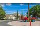 Community clubhouse entrance featuring vibrant floral arrangements, manicured landscaping, and ample parking at 4019 Venetian Bay Dr # 107, Kissimmee, FL 34741