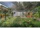 Backyard garden with various plants growing under a shaded netting structure at 42108 Pine Valley Dr, Paisley, FL 32767