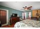 Cozy bedroom with hardwood floors, ceiling fan, and a rustic dresser at 42108 Pine Valley Dr, Paisley, FL 32767