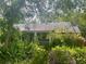 Charming home exterior surrounded by lush trees and plants at 42108 Pine Valley Dr, Paisley, FL 32767