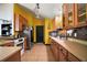 Well-lit kitchen featuring a full suite of appliances, wooden cabinets, tile flooring, and bright yellow walls at 42108 Pine Valley Dr, Paisley, FL 32767