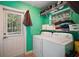 Functional laundry room with washer, dryer, shelving for storage and an exterior door to the backyard at 42108 Pine Valley Dr, Paisley, FL 32767