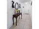 Inviting entryway with a decorative table, mirror, and sconces at 4529 Orchard Grove Rd, St Cloud, FL 34772