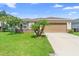 Charming single-story home featuring a lush green lawn and a two-car garage at 4529 Orchard Grove Rd, St Cloud, FL 34772