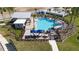 Community pool area showcasing lounge seating, picnic tables, shade umbrellas, and a covered patio area at 4693 Golden Knight Blvd, Kissimmee, FL 34746