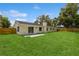 Large backyard with a well-manicured lawn, wooden fence, and mature trees at 5021 Saint Marie Ave, Belle Isle, FL 32812