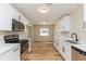 Modern kitchen with stainless appliances, white cabinetry, and wood-look flooring at 5021 Saint Marie Ave, Belle Isle, FL 32812