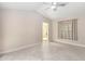 Spacious bedroom with tile floors and a ceiling fan, leading to the bathroom at 5057 Maui Cir # 15, Orlando, FL 32808