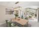 Bright dining area with modern lighting, light green chairs, and view to the living room at 5057 Maui Cir # 15, Orlando, FL 32808