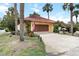 Single car garage and driveway, American flag, tropical plants, and lush green lawn at 5057 Maui Cir # 15, Orlando, FL 32808