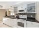 Well-lit kitchen boasts white appliances and cabinets with contrasting counters and backsplash at 5057 Maui Cir # 15, Orlando, FL 32808