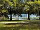 Scenic view of the lake from grassy area featuring mature trees at 5057 Maui Cir # 15, Orlando, FL 32808