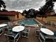 Inviting community pool with tables and chairs, perfect for relaxation and social gatherings amidst landscaped grounds at 5057 Maui Cir # 15, Orlando, FL 32808