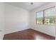 Cozy bedroom featuring hardwood floors, white walls, and a large window overlooking the front yard at 519 Cadiz Dr, Davenport, FL 33837