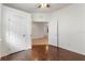 Well-lit room featuring hardwood flooring, neutral paint, ceiling fan, and multiple doorways at 519 Cadiz Dr, Davenport, FL 33837