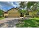Charming single-story home with a paver driveway, attached garage, and tropical landscaping at 519 Cadiz Dr, Davenport, FL 33837