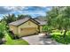 Eye-level view of this single-story home featuring a paver driveway, garage, and well-kept yard at 519 Cadiz Dr, Davenport, FL 33837