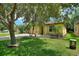 Charming home featuring a well-maintained lawn, mature tree, and appealing landscaping at 519 Cadiz Dr, Davenport, FL 33837
