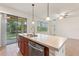 Open concept kitchen features an island with a sink, stainless steel dishwasher, and barstool seating at 519 Cadiz Dr, Davenport, FL 33837